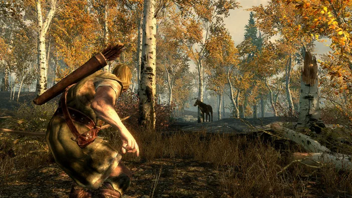 Dans The Elder Scrolls V: Skyrim, un personnage à l'arc se tient dans une forêt d'automne face à un cerf.