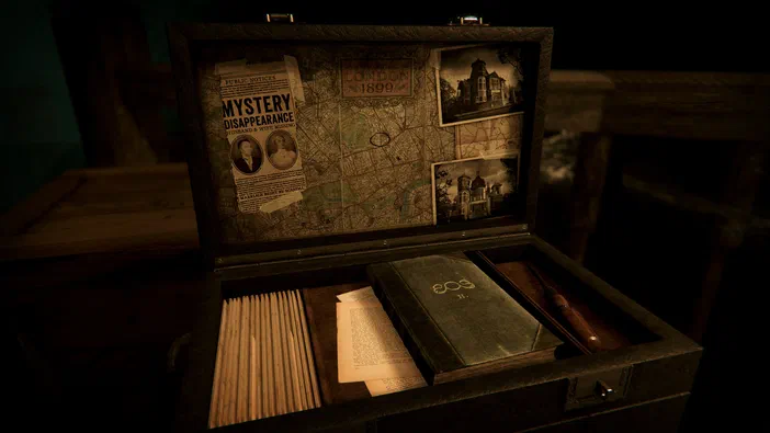 Boîte en bois ouverte contenant un livre vert, des papiers et des photos anciennes sur le couvercle intérieur.