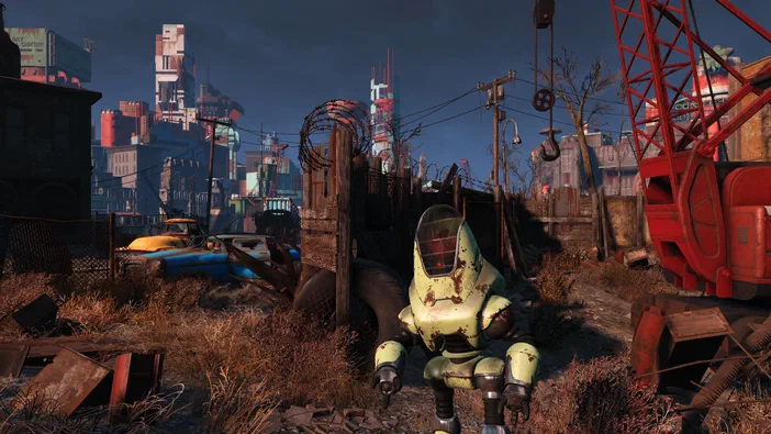 Un robot vert rouillé du jeu Fallout 4 se tient au milieu d'un paysage dévasté avec des véhicules abandonnés en arrière-plan.