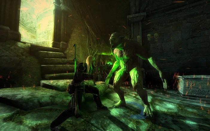 Dans The Witcher: Enhanced Edition, un personnage blond en armure se tient défensif devant une grande créature verte et musclée au sein d'un lieu souterrain sombre éclairé par des lueurs vertes.