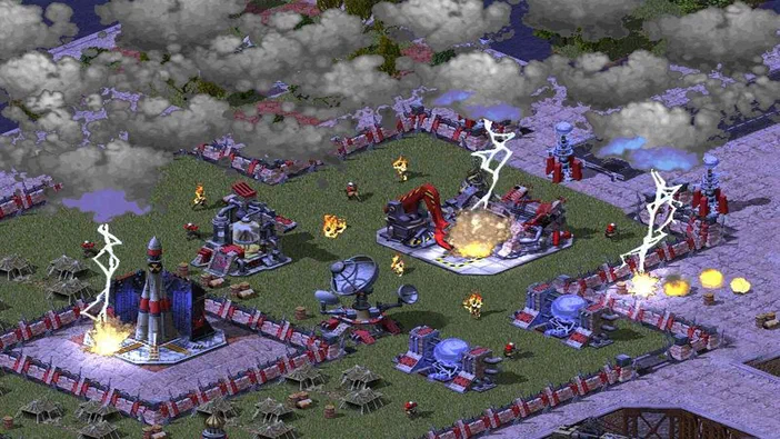 Capture d'écran du jeu vidéo Command & Conquer: Red Alert 2 and Yuri's Revenge montrant un champ de bataille soviétique avec des explosions, des flammes, de la fumée grise épaisse et des éclairs frappant les structures rouges dans le ciel gris.
