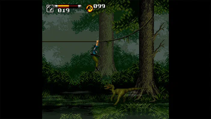 Capture d'écran du jeu vidéo Jurassic Park Classic Games Collection montrant un personnage accroché à une corde dans une forêt avec des dinosaures en bas.