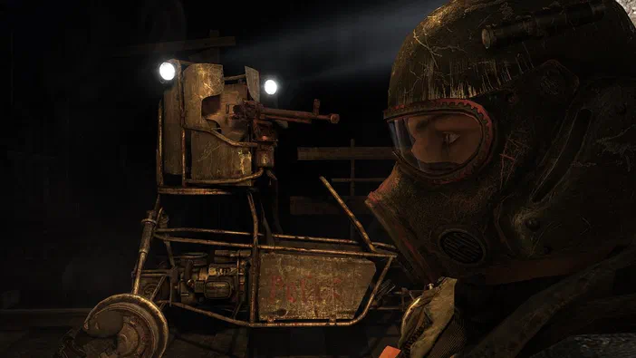 Capture d'écran du jeu vidéo Metro 2033 montrant un personnage en casque de protection face à une tourelle armée dans un environnement sombre.