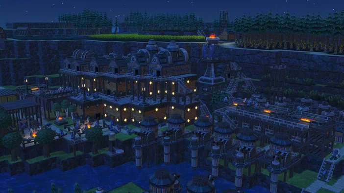 Vue de nuit d'une cité en bois complexe dans le jeu vidéo Timberborn, avec des bâtiments éclairés et une rivière au premier plan.