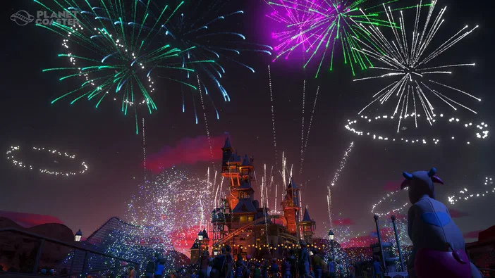 Capture d'écran du jeu Planet Coaster montrant un parc de loisirs en feu d'artifice nocturne avec des spectateurs et une statue.