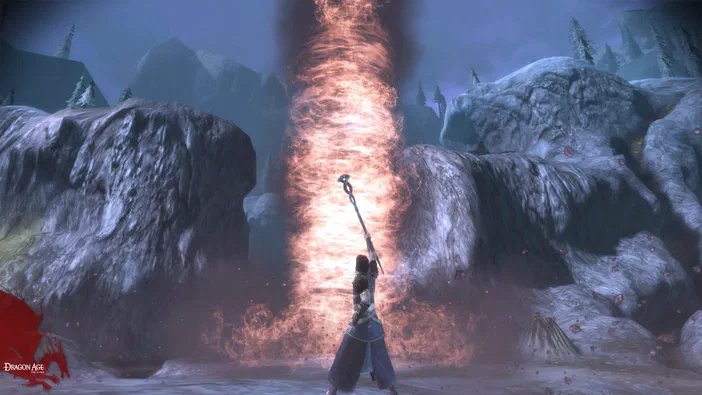 Dans le jeu vidéo Dragon Age: Origins, un personnage de dos tient sa baguette vers haut face à un tourbillon de flammes au milieu d'une vallée montagneuse couverte de neige.