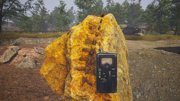 Dans le jeu Dinosaur Fossil Hunter, un détecteur de fossiles est posé sur une roche jaune parsemée d'empreintes fossilisées dans un environnement extérieur.