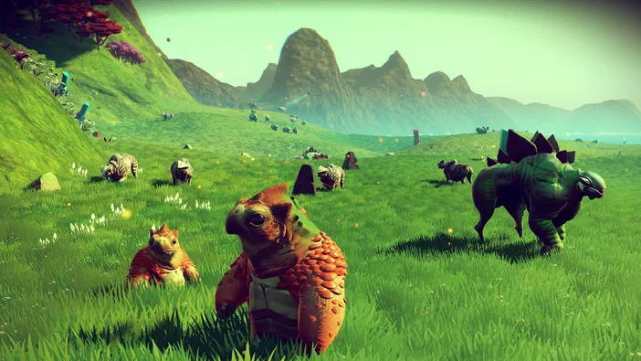 Capture d'écran du jeu vidéo No Man's Sky montrant un paysage verdoyant avec des créatures colorées, dont deux tortues orange et un dinosaure vert musclé, dans une prairie sous les montagnes.