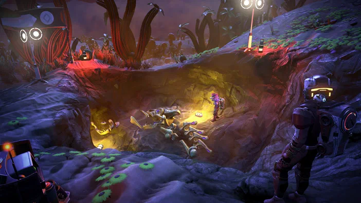 Capture de No Man's Sky montrant un personnage en armure observant des créatures étranges dans une grotte illuminée