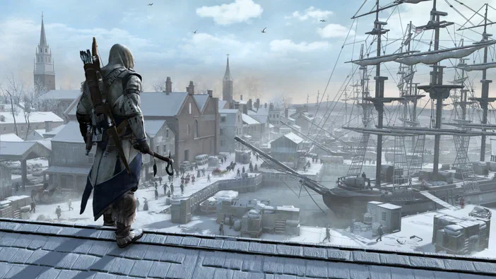 Dans Assassin's Creed III, un assassin en tenue blanche et bleue observe une ville enneigée avec des navires à voiles.