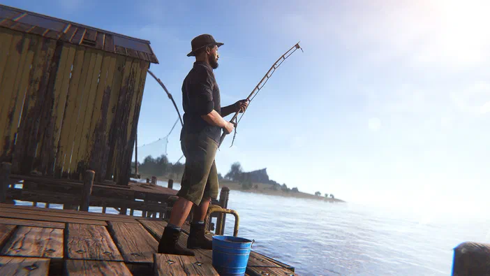 Dans le jeu Rust, un personnage barbu portant un chapeau et des bottes se tient sur une plateforme en bois près de l'eau, tenant une canne à pêche courbée.