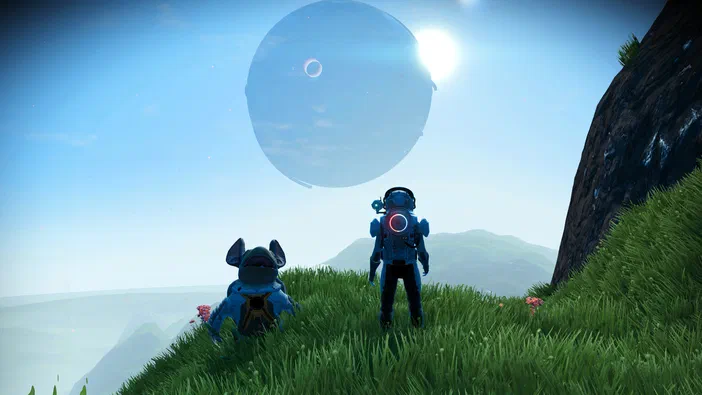 Deux personnages en combinaison spatiale observent un ciel bleu avec une planète et son satellite dans le jeu vidéo No Man's Sky.