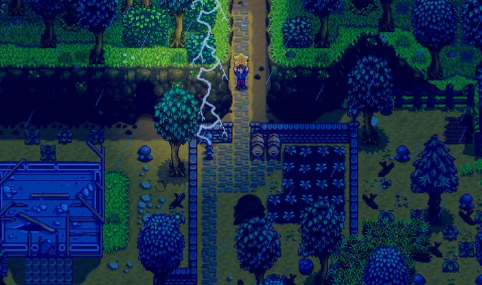 Capture d'écran du jeu Stardew Valley montrant un personnage sur une route de pierre entourée de champs et d'arbres sous la pluie.