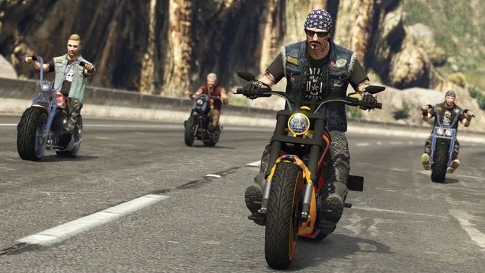 Capture d'écran de Grand Theft Auto V montrant quatre personnages à moto roulant sur une route ensoleillée.