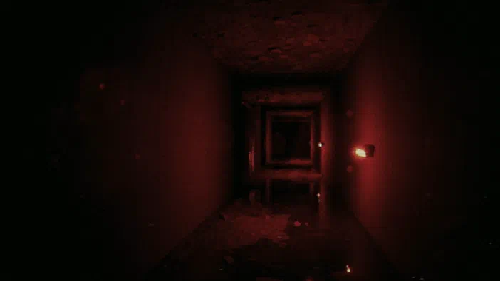 Capture d'écran du jeu Unknown Tapes montrant un couloir sombre et délabré baigné dans une lumière rouge intense.