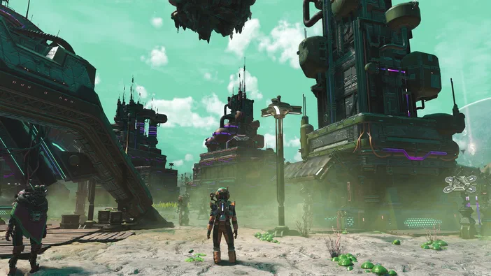 Capture d'écran du jeu vidéo No Man's Sky montrant un personnage en combinaison spatiale se tenant sur une planète aux structures futuristes et des vaisseaux dans le ciel.