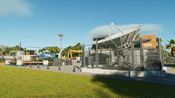 Vue d'un camp de base dans Jurassic World Evolution avec une antenne radar animée, un hélicoptère bleu et des conteneurs.