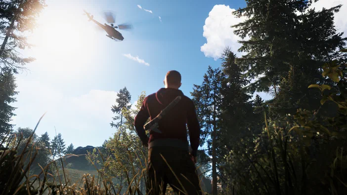 Dans le jeu Rust, un personnage vu de dos observe une hélicoptère survolant une forêt ensoleillée.