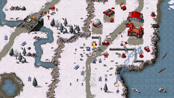 Capture d'écran de Command & Conquer Remastered Collection montrant une bataille en temps réel dans un paysage enneigé avec des unités et bases ennemies.