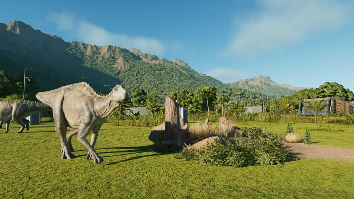 Deux dinosaures dans un environnement de jeu vidéo avec des montagnes et une végétation luxuriante.