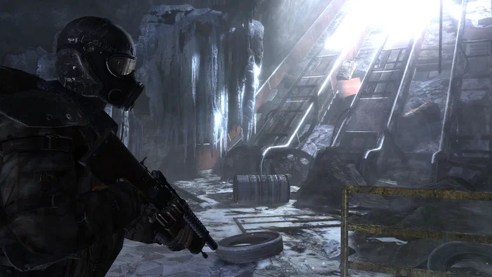 Dans le jeu vidéo Metro 2033, un personnage en armure et masque à gaz tient une arme dans une grotte glacée avec des rails de métro.