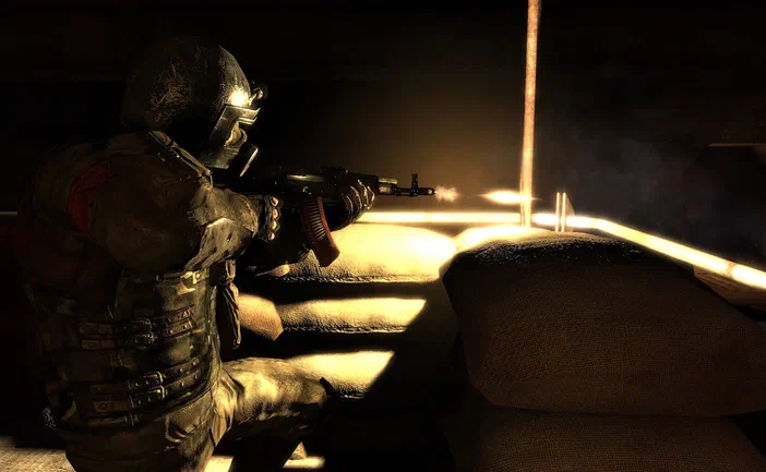 Dans le jeu vidéo Metro 2033, un soldat en armure se tient derrière des sacs de sable et tire son fusil d'assaut dans une zone sombre éclairée par la lumière du soleil.