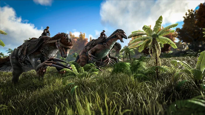 Dans le jeu ARK: Survival Evolved, deux dinosaures à plumes montés par des joueurs traversent une prairie herbeuse parsemée de palmiers sous un ciel bleu.