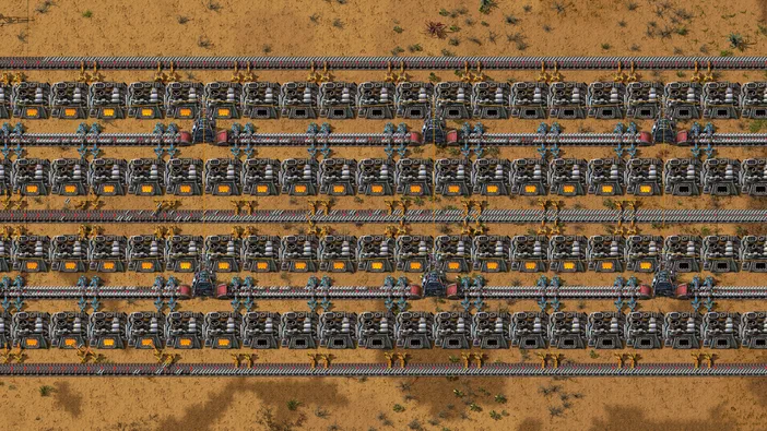 Vue de dessus d'une base complexe dans le jeu Factorio avec des lignes de production et des convoyeurs sur un terrain désertique.