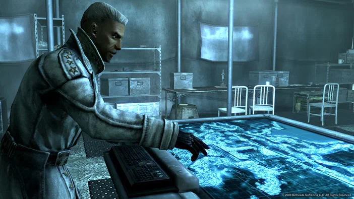 Dans Fallout 3 - Game of the Year Edition, un personnage en uniforme militaire examine une carte holographique bleue dans une pièce industrielle.