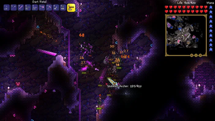 Capture d'écran du jeu Terraria montrant un personnage en combat dans une grotte sombre avec des effets de dégâts et l'interface utilisateur.