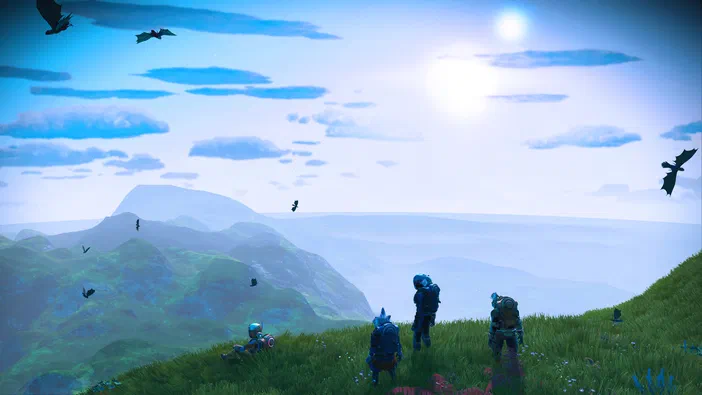Dans le jeu No Man's Sky, quatre personnages en combinaison spatiale observent un paysage de collines verdoyantes sous un ciel bleu parsemé d'oiseaux.