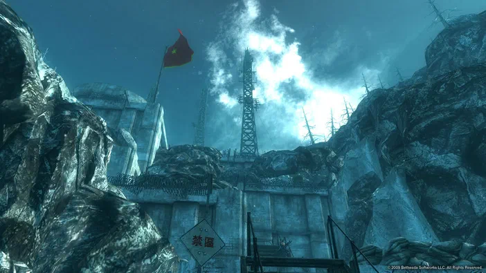 Vue d'un bunker militaire dans Fallout 3 avec un panneau 'Zone interdite' et des antennes sous un ciel bleu.
