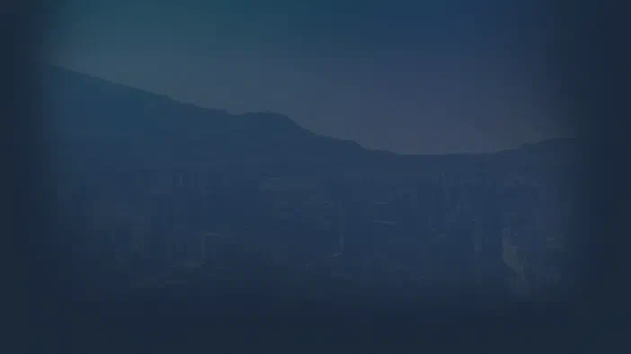 Vue noctuelle d'une ville avec des gratte-ciels et une montagne au loin dans le jeu Cities XL Platinum.
