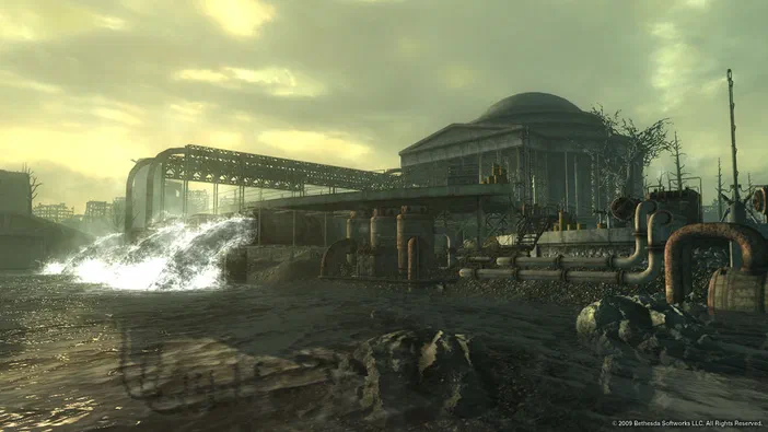 Capture d'écran de Fallout 3 montrant une usine abandonnée avec des tuyaux rouillés et un jet d'eau dans un environnement post-apocalyptique.