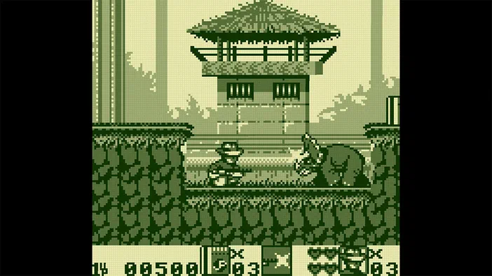 Capture d'écran du jeu Jurassic Park Classic Games Collection montrant un personnage et une créature dans un décor pixelisé vert avec des barrières.
