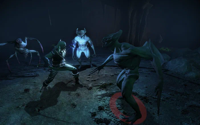 Dans une grotte sombre de The Witcher: Enhanced Edition, le protagoniste affronte trois créatures monstrueuses : un gobelin vert menaçant à droite, un être blanc au centre et une araignée géante sur la gauche.