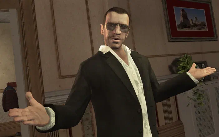 Dans Grand Theft Auto IV, un personnage masculin portant des lunettes de soleil et une veste noire étend les bras dans une pièce intérieure.
