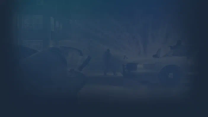 Fond d'écran de Grand Theft Auto IV montrant une rue urbaine brumeuse avec des véhicules et un personnage à pied.