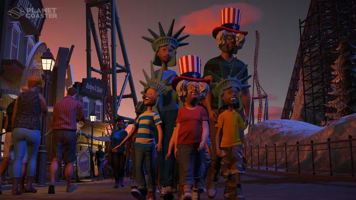 Capture d'écran du jeu Planet Coaster montrant des personnages et statues de la Liberté dans un parc à thème au coucher du soleil.