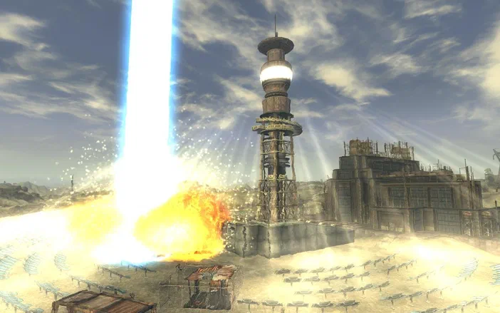 Capture d'écran de Fallout: New Vegas montrant une tour futuriste au centre d'une explosion lumineuse dans un désert.