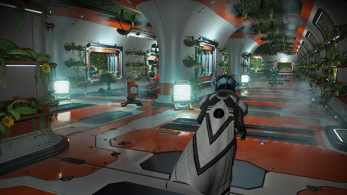 Dans le jeu vidéo No Man's Sky, un personnage en armure blanche se tient dans une base spatiale aux murs orange et blancs parsemés de plantes vertes.