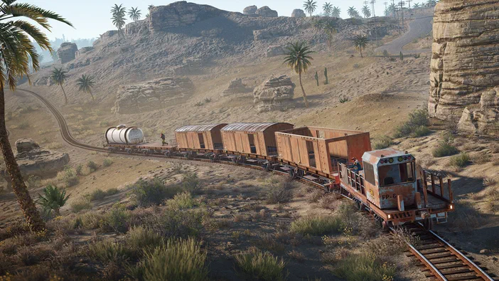 Dans le jeu Rust, un train de marchandises traverse une vallée aride parsemée de palmiers et de rochers.