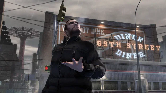 Dans Grand Theft Auto IV, Niko Bellic se tient devant le Diner de la rue 69e sous un ciel gris.