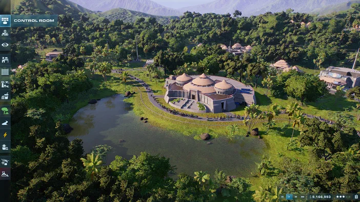 Vue aérienne d'une île verdoyante dans le jeu Jurassic World Evolution 2 avec un bâtiment central entouré de palmiers et une rivière.