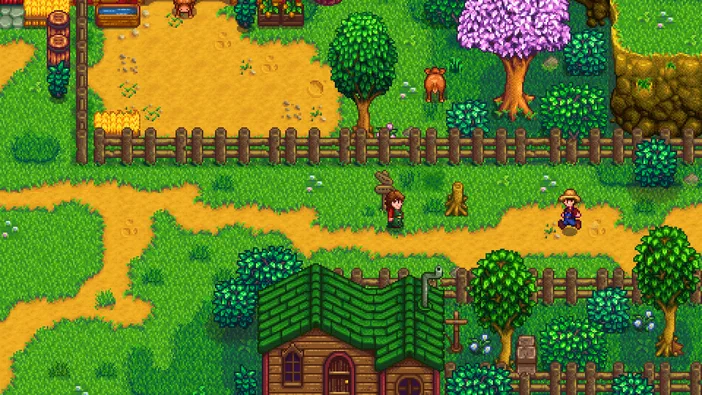 Capture d'écran du jeu Stardew Valley montrant un paysage rural avec des fermiers près de maisons et clôtures.