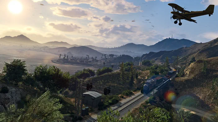 Vue aérienne d'un paysage montagneux avec un train et un avion dans le jeu vidéo Grand Theft Auto V