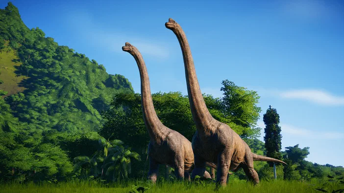 Deux dinosaures à long cou se tiennent dans une prairie verdoyante sous un ciel bleu clair avec des arbres et une colline en arrière-plan.