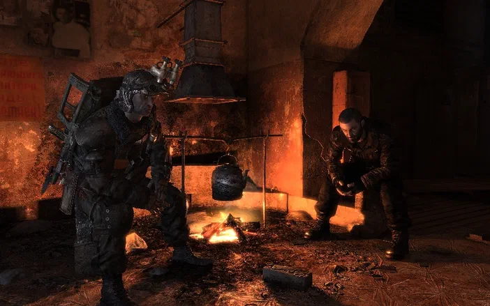 Dans le jeu vidéo Metro 2033, deux personnages en tenue de survie sont assis près d'un feu dans un sous-sol sombre.