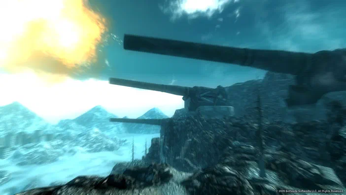 Capture d'écran de Fallout 3 montrant trois canons sur une colline rocheuse dans un paysage enneigé sous un ciel bleu et un soleil brillant.