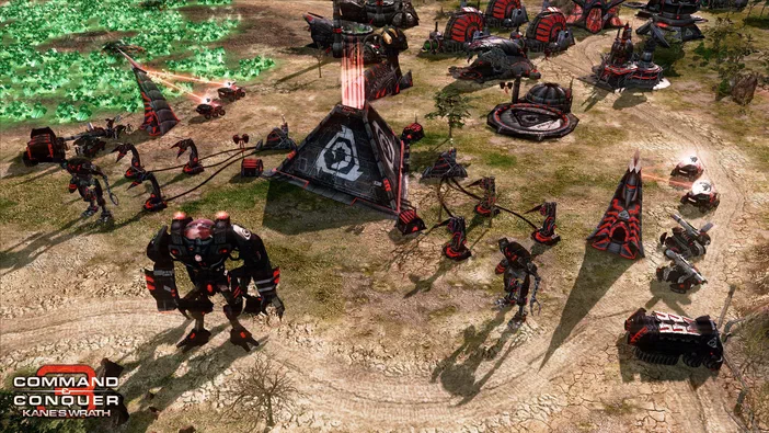 Capture d'écran du jeu de stratégie Command & Conquer 3: Kane's Wrath montrant une base ennemie avec des unités et véhicules noirs sur un terrain aride.